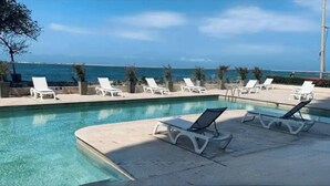 A pool area with lounge chairs and a view of the ocean. - Palmetto Sunset Ocean Front Cartagena Laguito 2904 (Cartagena)