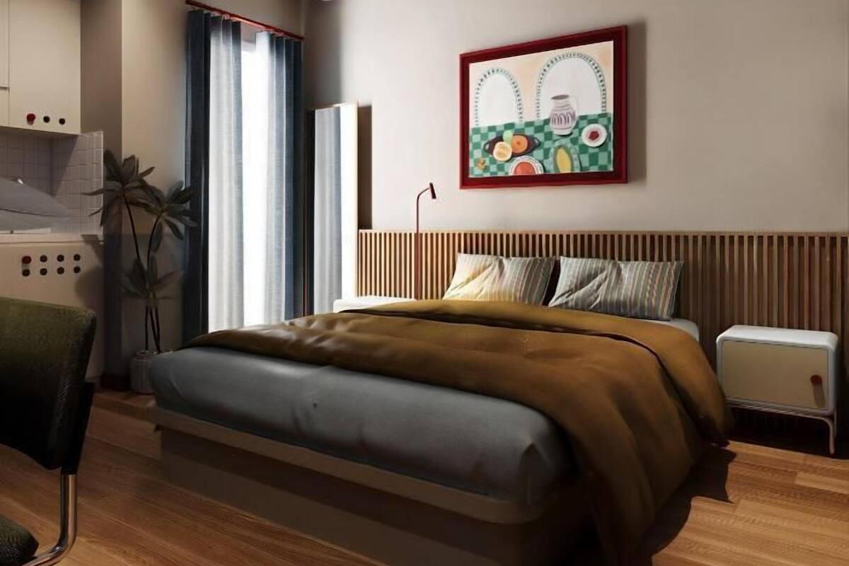 A modern bedroom with a bed, bedside table, and a wall-mounted air conditioner.