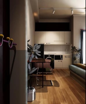 A modern kitchen with white cabinets, a dining area with a table and chairs, and a sofa. - The Rare Rooms by The Bloom - Saigon (Ho Chi Minh)