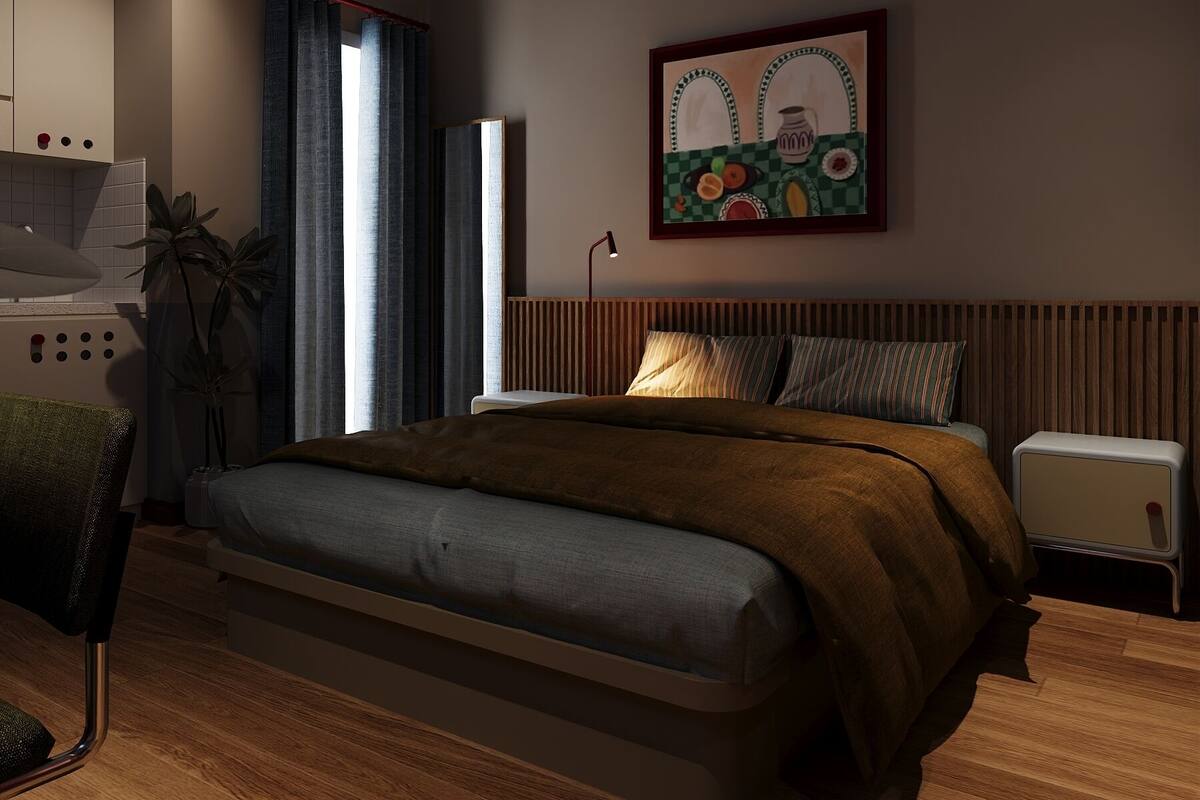 A modern bedroom with a bed, bedside table, and a painting on the wall.