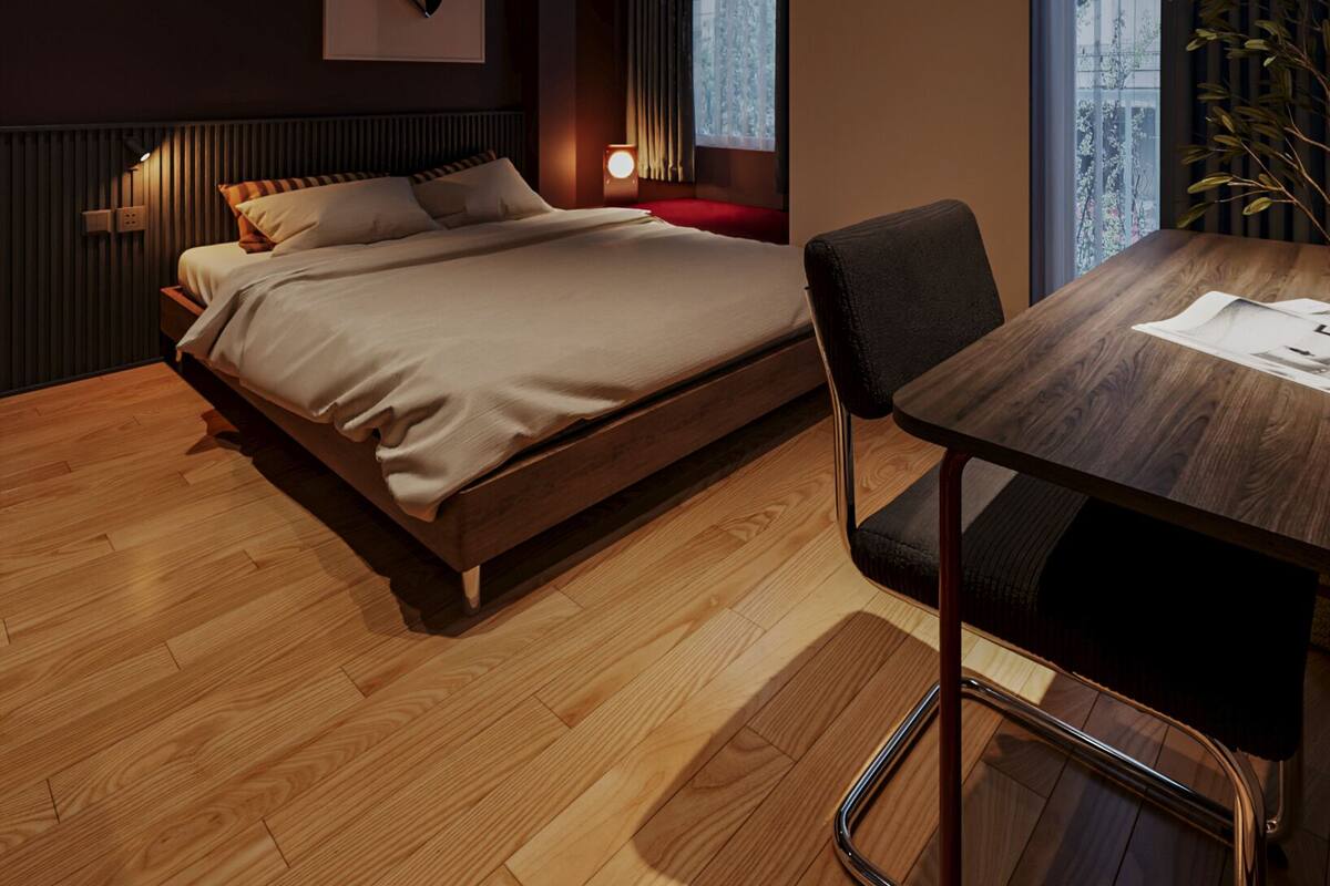 A modern bedroom with a bed, bedside table, chair, and a view of the city through the window.