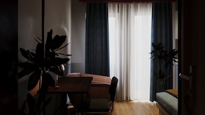 A room with a dining table, chairs, a sofa, and a potted plant. - The Rare Rooms by The Bloom - Saigon (Ho Chi Minh City)