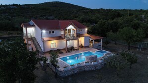 A two-story house with a swimming pool, a balcony, and a staircase leading to the upper floor. - Holiday home Tesija with private heated pool and jacuzzi (Lećevica)