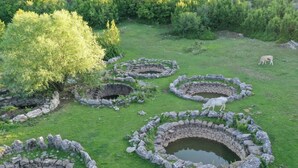 A historical site with stone structures and a pond, surrounded by greenery. - Holiday home Tesija with private heated pool and jacuzzi (Lećevica)