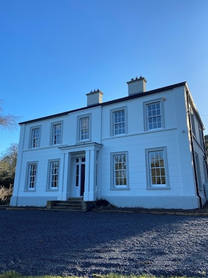 A two-story white building with a symmetrical facade, a central entrance with steps, and multiple windows. - Ashville Georgian House
Historic period property close to Strangford Lough (Newtownards)