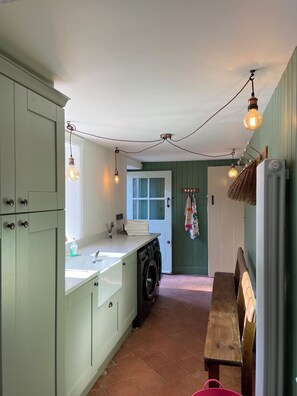 A kitchen with a washing machine, a sink, and a wooden bench. - Ashville Georgian House
Historic period property close to Strangford Lough (Newtownards)