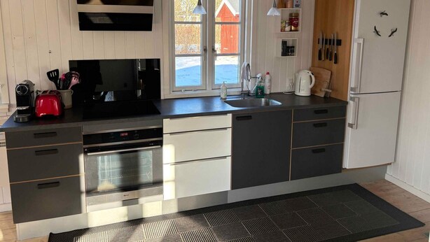 Eine moderne Küche mit Einbauofen, Kaffeemaschine und Kühlschrank.