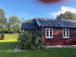 A red wooden house with a metal roof, a satellite dish, and a chimney. - 4 Star Holiday Home in Roslev (Roslev)