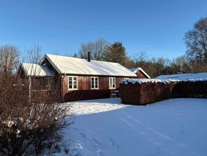 A single-story house with a snow-covered roof, a visible chimney, and a clear sky. - 4 Star Holiday Home in Roslev (Roslev)