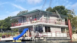 Un bateau avec un toboggan bleu, une tour de surveillance pour les sauveteurs et un drapeau.