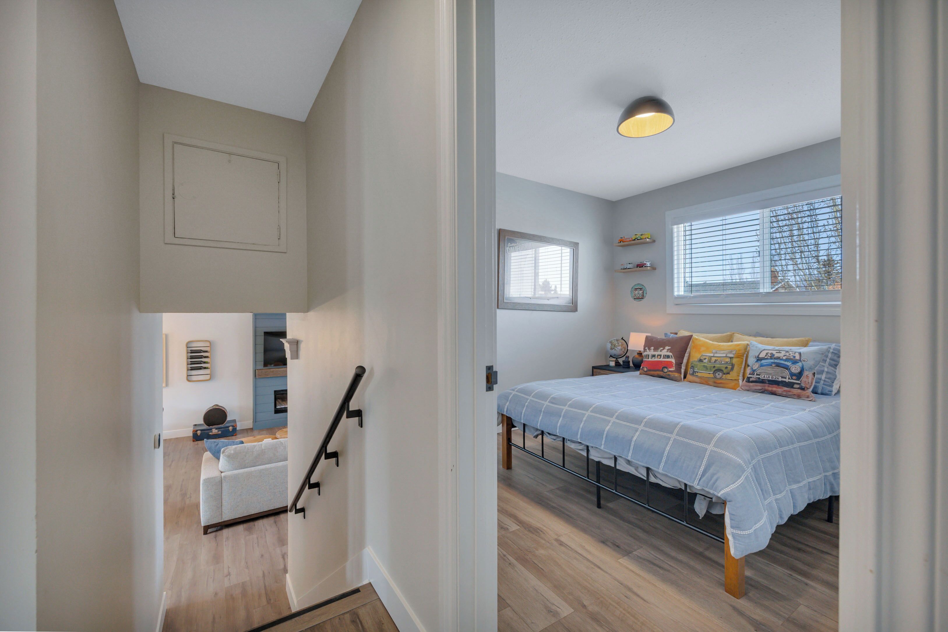 Un dormitorio con una cama, una ventana, una lámpara en el techo y un escritorio pequeño con un globo terráqueo.