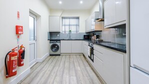 Une cuisine moderne équipée d’un lave-linge, d’un four à micro-ondes et d’une cuisinière.
