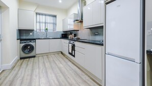 Une cuisine moderne équipée d’un lave-linge, d’un four et d’un réfrigérateur.