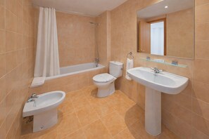 Ein Badezimmer mit Badewanne, Toilette, Bidet und Waschbecken.