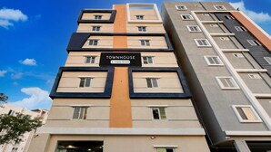 Un edificio a più piani con un cartello che riporta 'TOWNHOUSE' e 'Company-Serviced'.