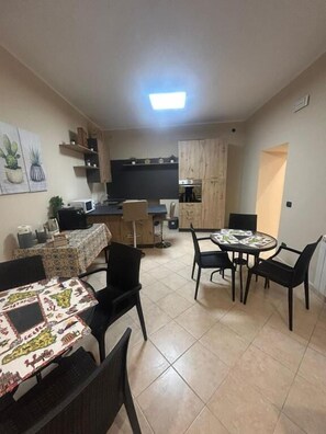A compact living space with a dining area, kitchen, and a small seating area.