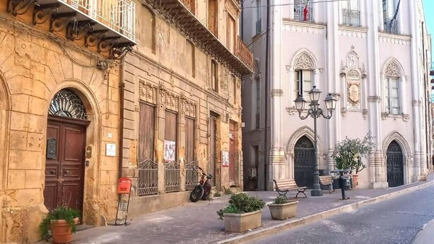 Una calle con edificios históricos, una tienda cerrada y una bicicleta estacionada.