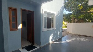 Un bâtiment à la façade bleue, avec une porte en bois et une fenêtre.