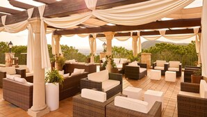 An outdoor patio with wicker furniture, draped white curtains, and a view of the landscape. - Apartment Inmas Nou With Shared Pool (Castell-Platja d'Aro)