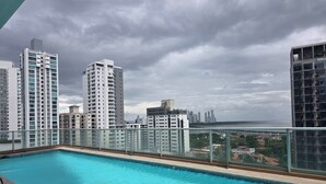 A rooftop pool with a view of high-rise buildings and a distant shoreline. - Brilliant 3-bedroom apartment with AC in vibrant Panamá (Panamá)