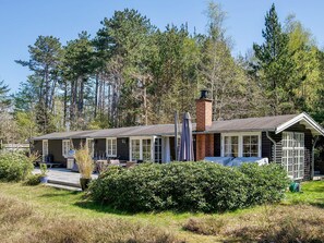 A cabin with a chimney, large windows, and a covered porch area. - 4 Star Holiday Home in Vig (Vig)