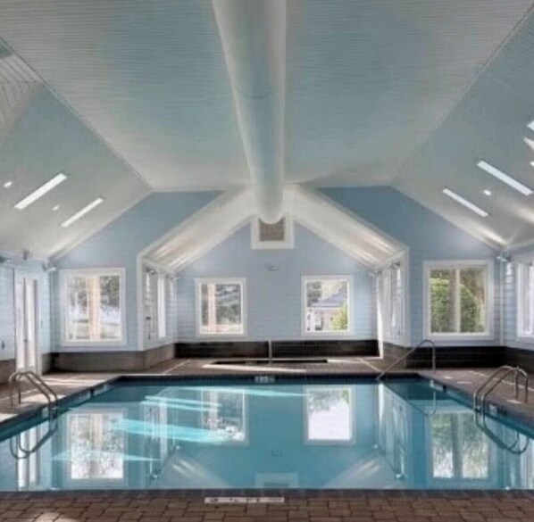 An indoor swimming pool with a high ceiling, large windows, and a clear view of the sky. - 3-bedroom Myrtle beach house just a short walk to beach. Includes golf cart. (Myrtle Beach)