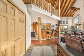 A spacious living area with a wooden staircase, a dining area, and a kitchen. - Henrys Reel Retreat (Island Park)