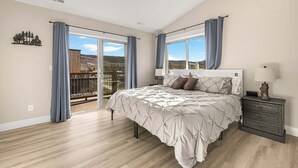 Una camera da letto con un letto, un comodino, una finestra e vista sull'esterno.