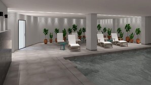 Un espace piscine intérieur moderne, doté de chaises longues, de plantes en pot et d’un sol carrelé.