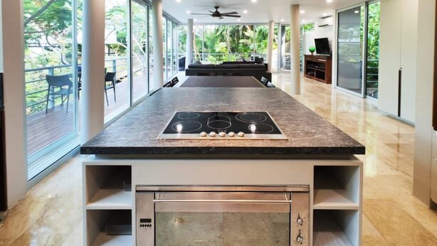 A modern kitchen with a central island, built-in oven, and a ceiling fan. - Luxurious Villa in Amapas, Zona Romantica, Malecon! (Puerto Vallarta)