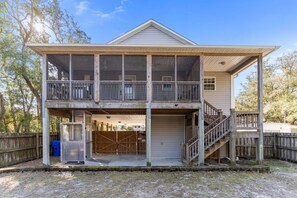 A two-story building with a balcony, a garage, and a wooden fence.