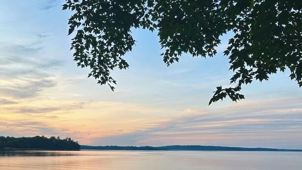 Two chairs facing a calm lake with a distant shoreline and trees. - Serene 2-bedroom lake house in welcoming Unity, perfect for relaxing stays (Unity)
