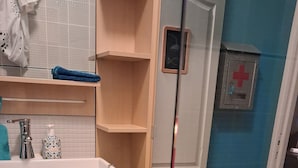 A bathroom with a sink, mirror, and shelves. - First floor room in a town house. (La Riche)