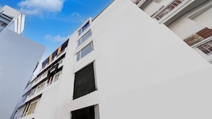 A modern building with multiple balconies, large windows, and a clear sky. - Townhouse Railway Road Katrathe Amro (Reasi)