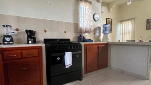 A kitchen with a stove, oven, and a water dispenser.