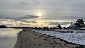 En strand med et hus i baggrunden.