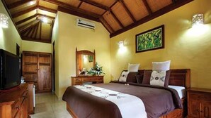 Un dormitorio con una cama de madera, un aparador, un televisor y un cuadro en la pared.