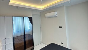 Un dormitorio moderno con cama, armario y aire acondicionado integrado.