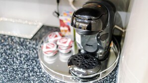 Una cafetera sobre una encimera con un soporte para cápsulas de café.