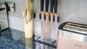 Una encimera de cocina con un juego de cuchillos, un tostador y un recipiente para utensilios.