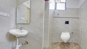 Un bagno con lavandino, specchio, WC e doccia.