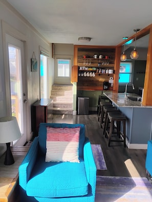 Une cuisine moderne dotée d’un îlot central, de tabourets de bar et d’un coin repas avec un canapé bleu.