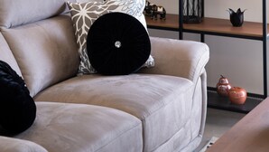 A modern living room with a sofa, decorative fish sculptures, and a wall-mounted shelf with various items. - Carmen Sea View Maisonette (Lefkada)