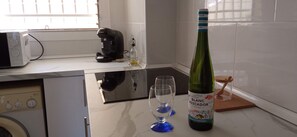 Eine Küche mit einer Bosch-Kaffeemaschine, einer Weinflasche und zwei Weingläsern auf der Arbeitsplatte.