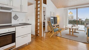 A modern kitchen with white cabinets, a built-in oven, and a wooden ladder. - 4 Star Holiday Home in Ronde (Ronde)