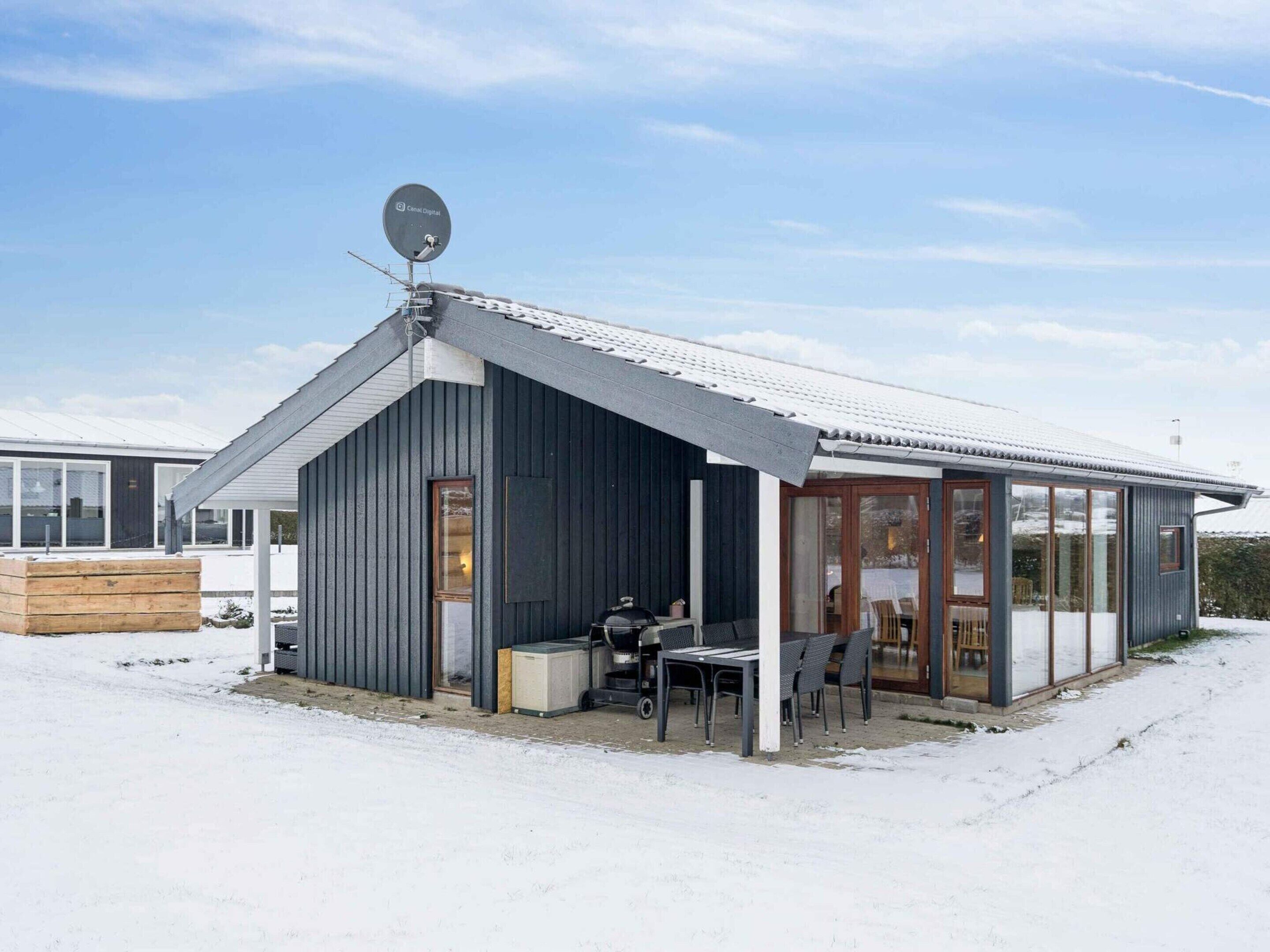 A modern building with a sloped roof, a satellite dish, and a covered outdoor seating area.