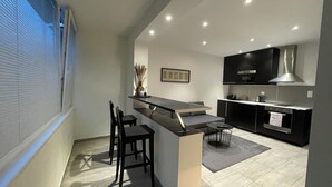 Una cocina moderna con barra, armarios negros y una estufa grande.