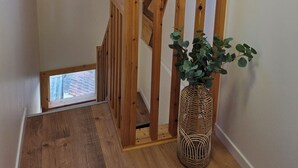 A wooden staircase with a skylight, a wicker vase with green foliage, and a view of the outside. - Cocon Bohème Le Portel House 12 pers(+2) beach 15 min walk (Le Portel)