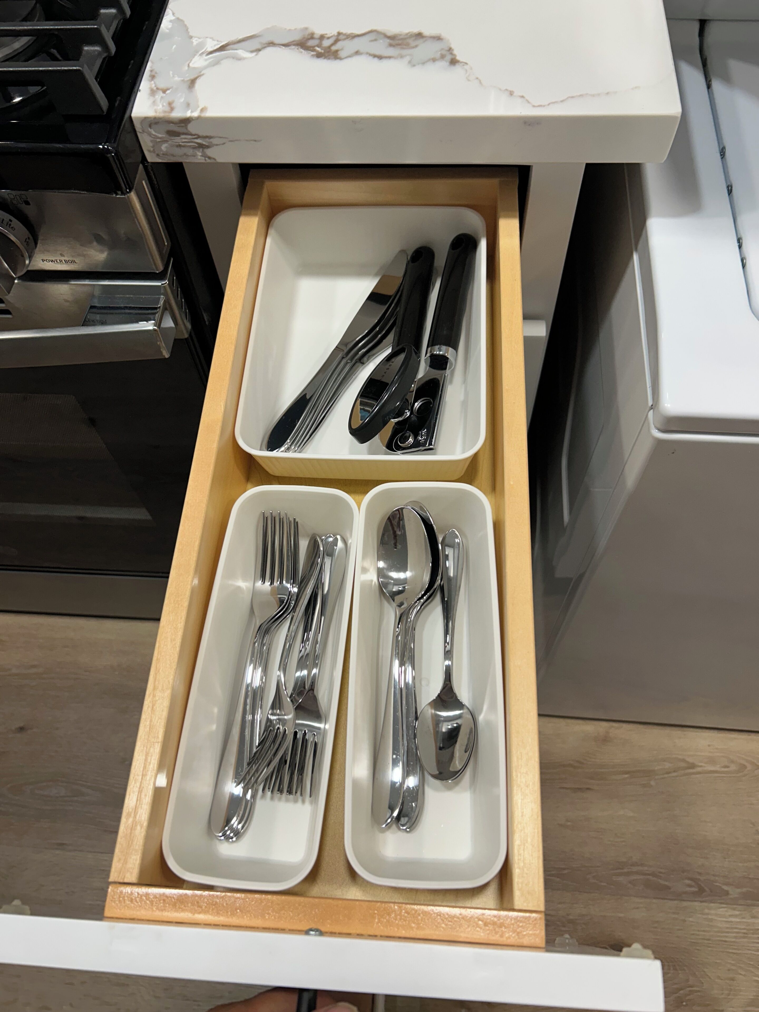Un tiroir contenant des couverts bien rangés, notamment des fourchettes, des couteaux et des cuillères.