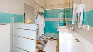 Een douche, een haardroger, pantoffels, handdoeken